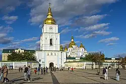 Photograph of the monastery's front section, with the rebuilt bell tower in the foreground