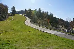 mountain road heading uphill, with grassy plains on one side