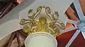 Close-up of the top part of a pillar, showing gold painted carvings detail.