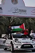 Alaa Rasheed raising the Jordanian flag in Dubai International Rally