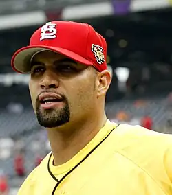 A man in a yellow shirt and a red baseball cap