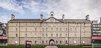 Facade of the former Collins Barracks with museum signage in the foreground.