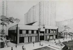 Black and white architectural drawing of a two-level community center based between tall housing units.