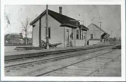 A black-and-white postcard of a one-story wooden railway station