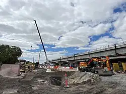 Construction site with cranes and construction equipment with a concrete railway viaduct on the right