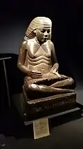 Scribe statue of Amenhotep, son of Hapu; circa 1390-1352 BC; granodiorite; height: 1.3 m; from Karnak (Egypt)[5]