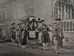 Photograph of Carlo Rossetti being carried in a litter