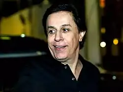 Tom Cavalcante looking to the right side of a camera.