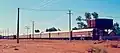 The Ghan in the narrow-gauge diesel-hauled era (pre-1980): the train, headed by an NJ class locomotive, is ready to depart Alice Springs, about 1973
