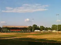 View of a grandstand and baseball field from the furthest point of the outfield