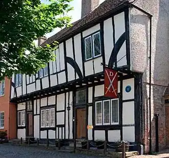 Black and white half-timbered house surrounded by trees