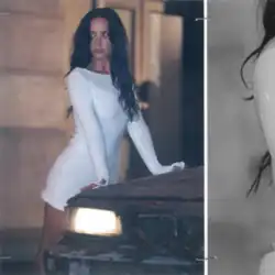 Lovato leaning on the a car hood and glancing sideways