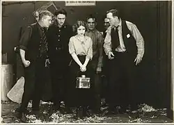 Black and white film still showing actors in period costume