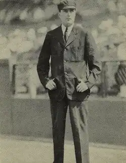 Black and white full shot image of a baseball umpire standing on the baseball diamond.
