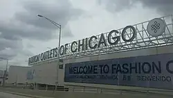 Fashion Outlets of Chicago mall with LED screens on the walls seen from Interstate 294
