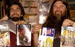 George DiCaprio and Ron Turner holding up comic books including Commies from Mars and Cherry Poptart
