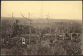 Sepia toned photo shows field fortifications built from logs.