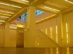 View of a below ground stairwell leading to the main floor in yellow light