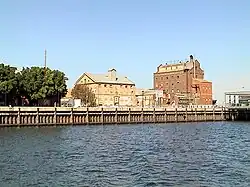 Hart's Mill (1855, centre) and the Adelaide Milling Company flour mill (c.1890, right) are prominent landmarks adjacent to the southern wharf of the Inner Harbour at Port Adelaide., 34°50′33.2″S 138°29′58.4″E / -34.842556; 138.499556