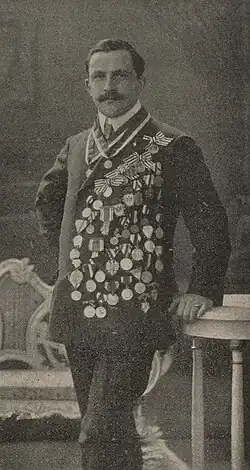 A black and white portrait photo of Otto Hooff standing and wearing a suit jacket with many medals.