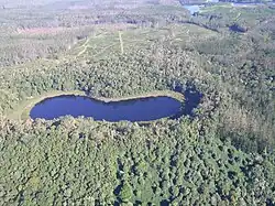 Aerial view of the dumbbell-shaped double crater of Lake Euramoo, surrounded by tropical rainforest.