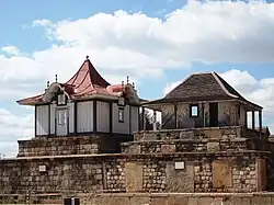 Two rectangular stone tombs, each topped with a small decorative wooden house