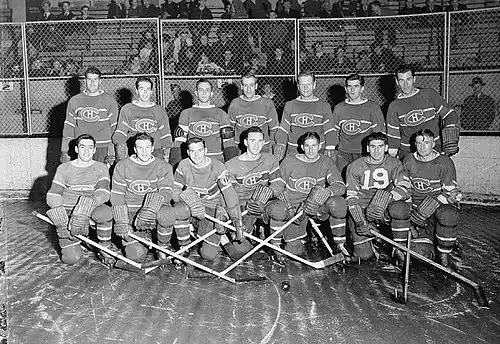 1942 Montreal Canadiens posing for photo on rink. First row of seven players kneeling and the second row of seven players standing behind.