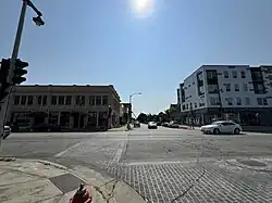 A street intersection. On the right is a mixed-use building labelled "America's Black Holocaust Museum". On the left is a two-story brick building.