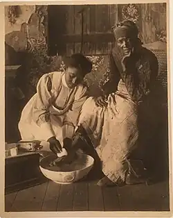Young woman washing an older woman's foot, St. Helena Island, SC. Vintage platinum print from the Leigh Richmond Miner Archive.