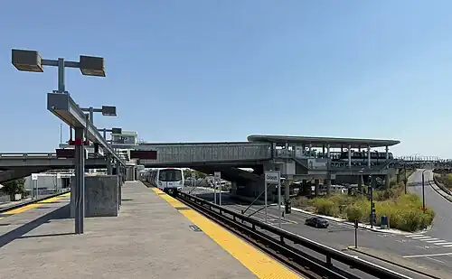 An elevated rapid transit station with a second platform connected at one end