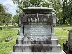 A large headstone reading "BEATTY" in all caps with the names of the subject and his wife, and the birth and death dates of both persons.