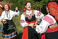 Russian women with treshchotka and spoons in their hands. The two women on the right are wearing Sarafans.