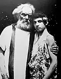 An old man and a boy wearing Ancient Greek-like clothes