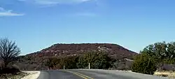 Round Mountain, a butte located 6 mi (9.7 km) to the northwest of Comanche, Texas, where Robert T. Hill first observed Lower Cretaceous fossils and strata. (31°55′30″N 98°42′07″W﻿ / ﻿31.925°N 98.702°W﻿ / 31.925; -98.702) (30 December 2008)