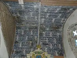 Photograph of a panelled vault painted dark blue, with cherubs holding rosaries