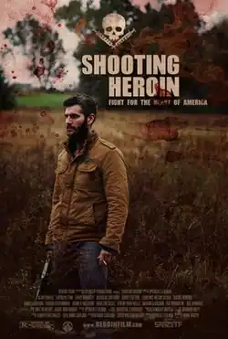 Poster for the film Shooting Heroin featuring a bearded man in a brown jacket standing in a field with a serious expression, holding a gun. The background consists of overgrown grass and trees under a cloudy sky. Blood splatters overlay the image, along with a skull and crossbones symbol at the top. The tagline "Fight for the Heart of America" is placed under the bold, distressed title text.