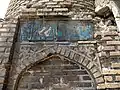 One of the façades of the minaret's base, with a blind arch and inscription panel in turquoise tile
