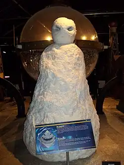 A large white mound with a white sphere on top of it, resembling the shape of a person. It is constructed in a way that resembles snow.