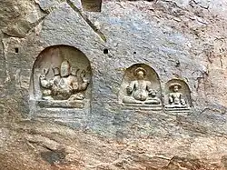 Bas-reliefs on the left side of cave temple entrance.