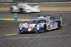 White-and-blue race car rounding a curve