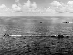 USS Canberra (foreground) and Houston (background) under tow on 18 October