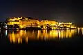 Night view of Udaipur city palace by lake Pichola, a view from Ambrai ghat.