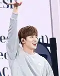 Wonwoo holding his right hand up as part of the choreography of "Queencard"