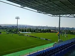 A natural grass pitch and the swimming pool near the main stadium