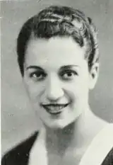 A photograph of a young smiling woman with short dark glossy hair and dark eyes.